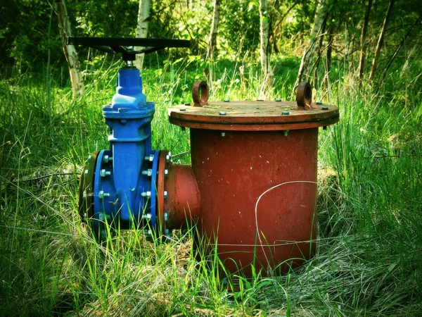 Old expansion pipe of drink water pipes joined with new blue valve and new blue joint members. New dump valve.  Extreme kind of corrosion, metal corroded texture. — Stock Photo, Image
