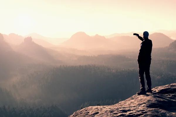 Turista magro no pico agudo da rocha no parque de impérios de rocha está olhando sobre o vale nebuloso e nebuloso para o sol — Fotografia de Stock