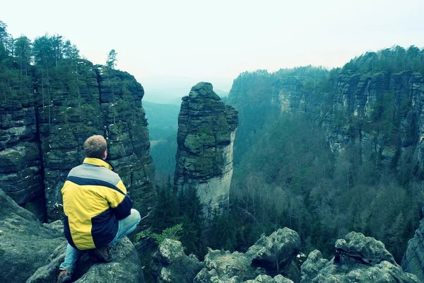 Homem caminhante turístico no pico da rocha em montanhas rochosas — Fotografia de Stock