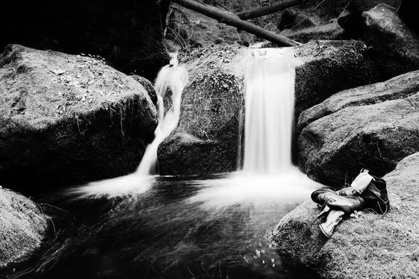 Hiker high boots and sweaty grey socks. Resting on the mossy boulder at the  nice mountain stream — Stock Photo, Image