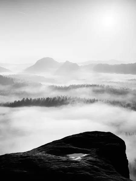 Fantastiska sunrise på toppen av den steniga bergen med vyn in dimmiga dalen — Stockfoto