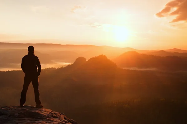 L'escursionista si trova sull'angolo acuto della roccia arenaria nel parco degli imperi rocciosi e osserva la nebbiosa e nebbiosa valle del mattino fino al sole. Bellissimo momento il miracolo della natura — Foto Stock