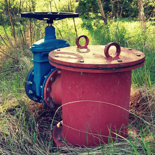 Old expansion pipe of drink water pipes joined with new blue valve and new blue joint members. New dump valve.  Extreme kind of corrosion, metal corroded texture.