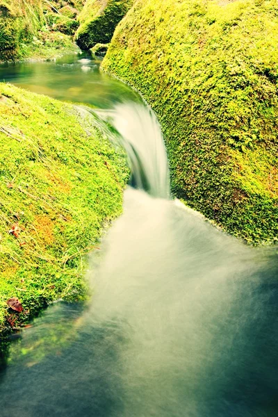 Cascade on small mountain stream. Cold crystal  water is falling over basalt mossy boulders into small pool. — Stock Photo, Image