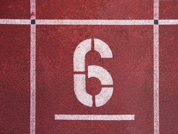 Número seis. Número de pista branca na pista de corrida de borracha vermelha, textura de pistas de corrida no estádio atlético — Fotografia de Stock