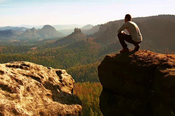 Tourist hiker man on the rock peak  in rocky mountains — Stock Photo, Image