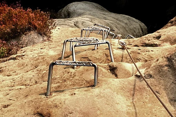 Escaladores escada de metal via ferrata. Ferro corda torcida fixada em bloco por parafusos encaixe ganchos. A extremidade da corda ancorada em pedra de arenito . — Fotografia de Stock