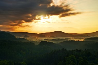Işıklı kayalar ve tepeler günbatımı güneş ufukta feryat. Karanlık siluetleri.