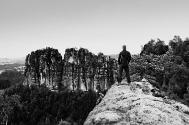 Climber erkeği keskin uçurum ve dağlar izle siyah. Kayaçların karanlık siluet.