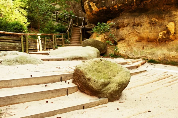 Gran roca arenisca cayó en medio de la ruta turística. Escalones de madera . —  Fotos de Stock