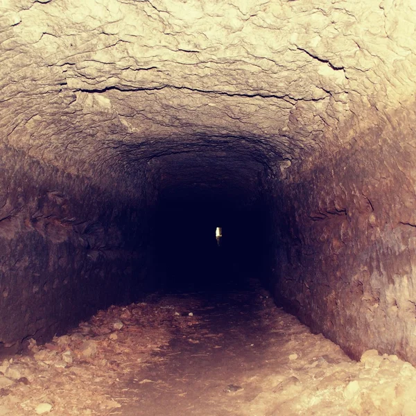 Viejo túnel, paredes humedecidas. Canal seco tallado en piedra arenisca — Foto de Stock