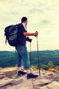 Fotoğrafçı büyük ayna kamera boyun ve sırt çantası ile kaya tepe üzerinde kal. Dağlık manzara, taze yeşil renk Vadisi.