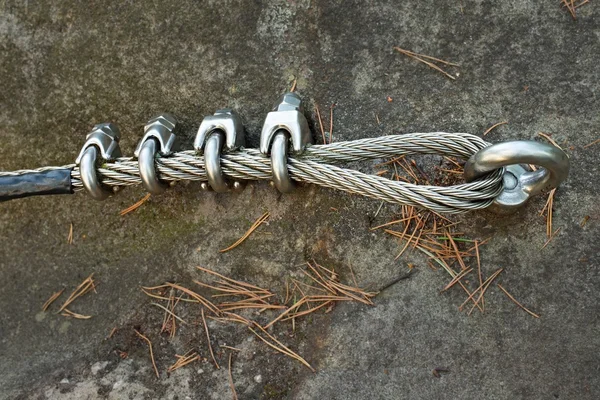 Dağ duvar carabine kumtaşı kaya ile. Döngü içinde çelik ipin ucunda.