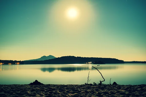 Romantische Vollmondnacht am See, ruhiger Wasserstand mit Mondstrahlen. Burh auf dem Hügel. — Stockfoto