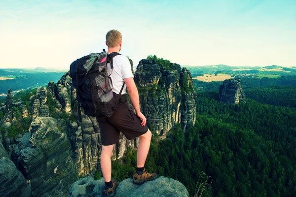 Turist med stor ryggsäck. Solig kväll i klipporna i Sachsen Schweiz park. Vandrare stå på rocky utsiktsplats över dalen. — Stockfoto