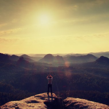 Adam akıllı telefon ile fotoğraf rock İmparatorluğu'nun peak alır. Rüya gibi adamlara manzara, Bahar Turuncu pembe puslu sunrise güzel vadi Saksonya'nın İsviçre Park.