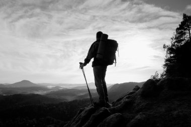Turist büyük sırt çantası ve eller stand içine derin puslu Vadisi feryat Polonyalılar kayalık bakış ve izle. Rocky Dağları'nda güneşli gün doğumuna.
