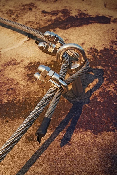 Eay bolt in the middle. Steel anchor bolt eye in rock. The fixed  steel rope. Climbers path via ferrata. Twisted rope fixed in rock. — Stock Photo, Image