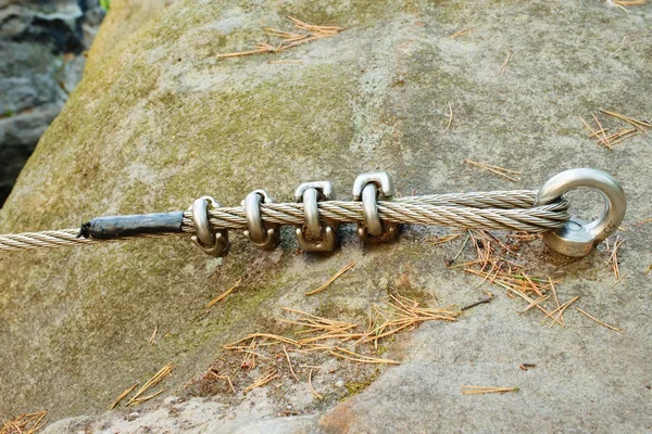 Mountain wall with carabine in the sandstone rock. End of the steel rope in loop. — Stock Photo, Image