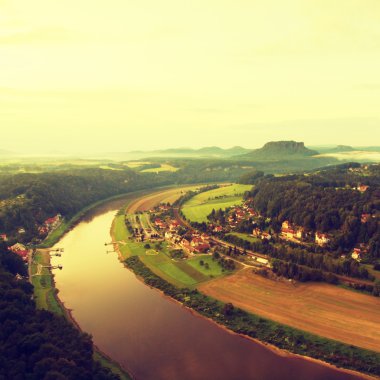 Early spring morning above big river after rainy night, fresh blue cloud in the sky. Spring green forests in landscape, daybreak at horizon