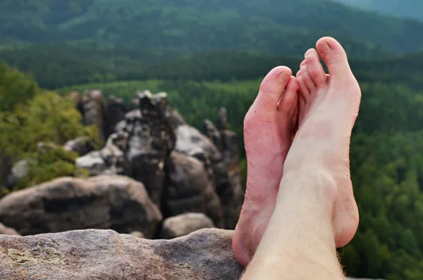 Meztelen férfi izzadt hosszú lábak, a csúcs-völgy felett éles rock. — Stock Fotó