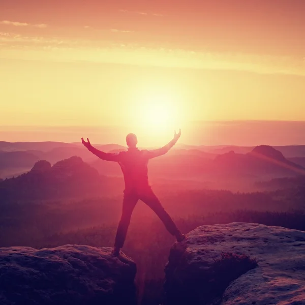 두 개의 바위 봉우리 사이 승리를 축 하 블랙에 등산객을 점프. 태양이 머리 위에 멋진 새벽.. — 스톡 사진