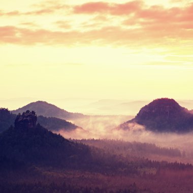 Kırmızı daybreak. Puslu sabah güzel bir Hills. Hills doruklarına sisli arka plandan dışarı taşıyorsa, kırmızı ve turuncu güneş ışınları nedeniyle sis olduğunu.