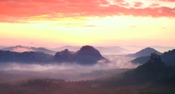 Красная туманная пейзажная панорама гор. Мечтательный восход солнца на скальных горах. Туманная туманная долина — стоковое фото
