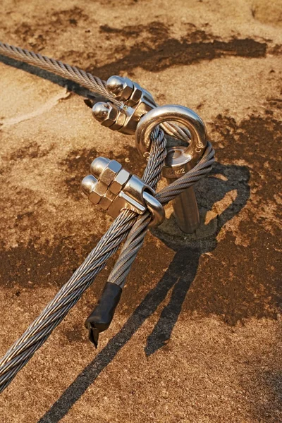 Eay bolt in the middle. Steel anchor bolt eye in rock. The fixed  steel rope. Climbers path via ferrata. Twisted rope fixed in rock. — Stock Photo, Image