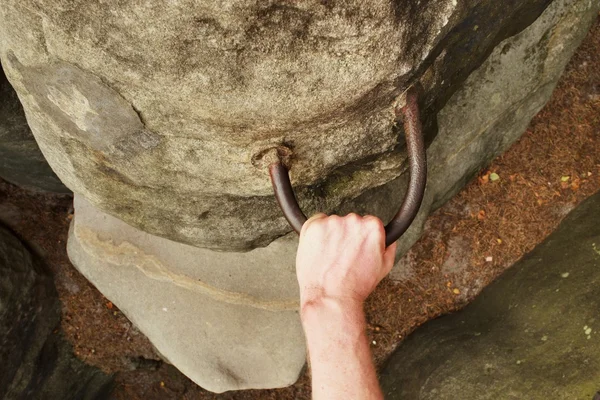 Skalní lezec ruce na ocelové držadlo v pískovcové skále. Turistické cesty via ferrata. — Stock fotografie