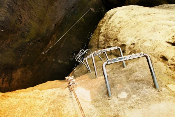 Horolezci kovový žebřík via ferrata. Železo kroucené lano v bloku odstraněných šroubů Karabinky. Konec provazu, který je ukotven do pískovcové skály. — Stock fotografie