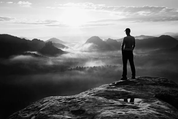 Einsame Wanderer in weißem Hemd und roter Mütze stehen auf Felsgipfeln im Park der Felsenimperien und wachen über neblig-nebeliges Tal zur Sonne. das Wunder der Natur — Stockfoto
