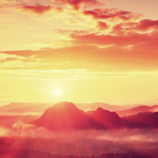 Kırmızı puslu daybreak. Sisli sonbahar sabahı güzel Hills. Hills doruklarına zengin renkli bulutlar yapışkanlık dışarı. — Stok fotoğraf