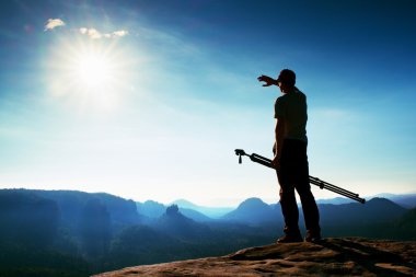 Fotoğraf meraklısı tripod cliff ve düşünme ile kal. Rüya gibi adamlara manzara, mavi puslu gündoğumu bir güzel vadi