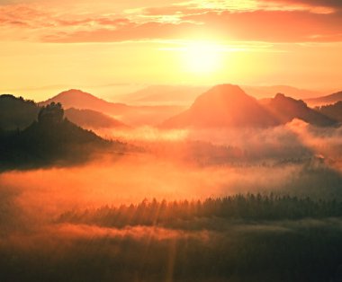 Muhteşem kırmızı uyanış. Sonbahar güzel vadi. Hills doruklarına kırmızı ve turuncu güneş ışınları sis yapışkanlık dışarı.