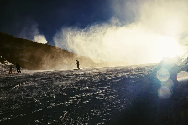 Skidåkare nära en snö kanon att göra pudersnö. Alperna skidort. — Stockfoto
