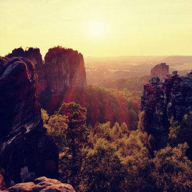 Işıklı kayalar ve tepeler günbatımı güneş ufukta feryat. Karanlık siluetleri.