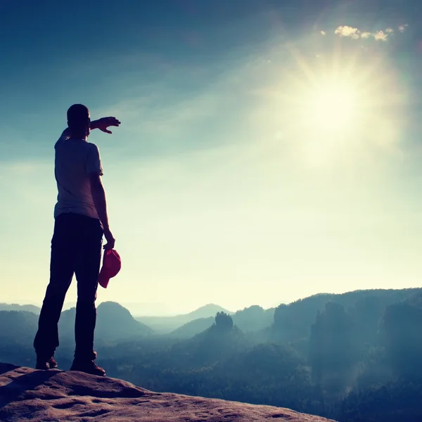 Escursionista in berretto rosso sulla cima della roccia nel parco imperi rocciosi e guardando la nebbiosa e nebbiosa valle del mattino al sole. Bellissimo viaggio . — Foto Stock