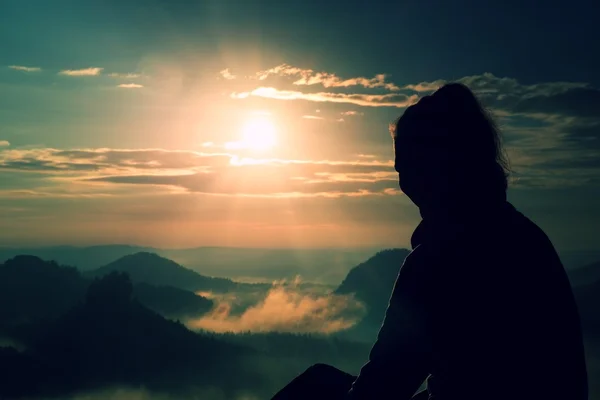 Beautiful  young long hair girl tourist enjoy daybreak on the sharp corner of sandstone rock and watch over valley to Sun. — Stock Photo, Image