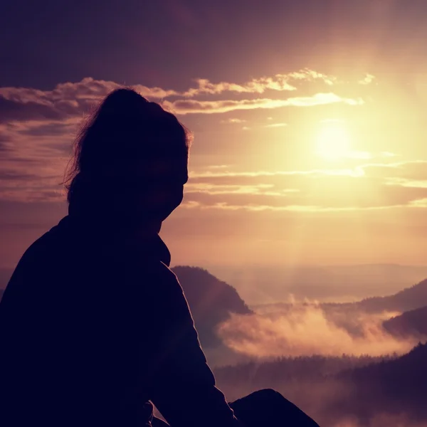 Beautiful  young long hair girl tourist enjoy daybreak on the sharp corner of sandstone rock and watch over valley to Sun. — Stock Photo, Image