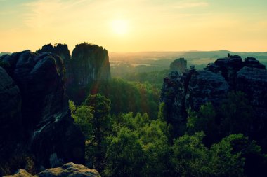 Işıklı kayalar ve tepeler günbatımı güneş ufukta feryat. Karanlık siluetleri.
