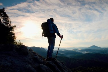 Turist büyük sırt çantası ve eller stand içine derin puslu Vadisi feryat Polonyalılar kayalık bakış ve izle. Rocky Dağları'nda güneşli gün doğumuna.