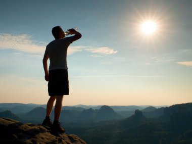 Susuz siyah uzun yürüyüşe çıkan kimse su şişe içecekler pantolon. Terli yorgun turist kumtaşı kayalık park Saksonya İsviçre tepe üzerinde