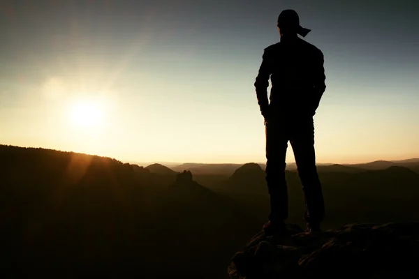 Wanderer mit langer Mütze auf Felsen und Blick in die Sonne. schöner Moment das Wunder der Natur — Stockfoto