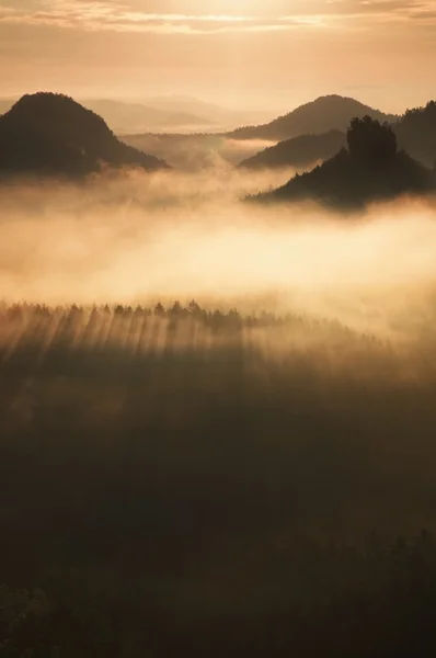 Далекий горный хребет и тяжелые облака разноцветного тумана над глубокими долинами — стоковое фото