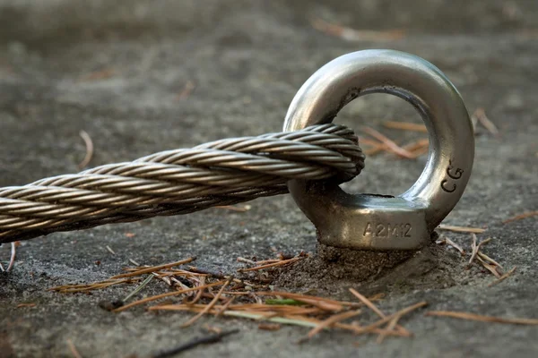 Detail of steel bolt anchor eye in rock. The end knot  of steel rope. Climbers path in rocks via ferrata. Iron twisted rope fixed in block. — Stock Photo, Image