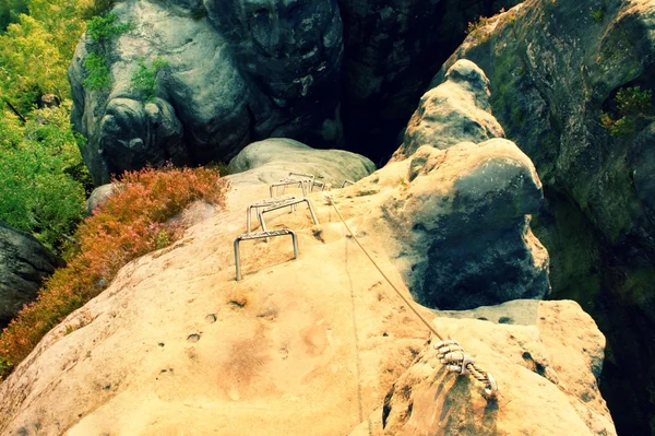 Horolezci kovový žebřík via ferrata. Železo kroucené lano v bloku odstraněných šroubů Karabinky. Konec provazu, který je ukotven do pískovcové skály. — Stock fotografie