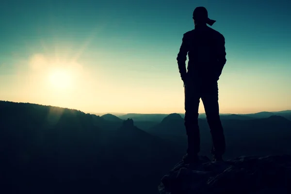 Escursionista in lungo cappello su impero rock e guardando al sole. Bellissimo momento il miracolo della natura — Foto Stock