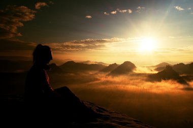 Güzel genç uzun saçlı kız turist daybreak kumtaşı kaya keskin köşesinde zevk ve Sun Vadisi'ne üzerinden izlemek.