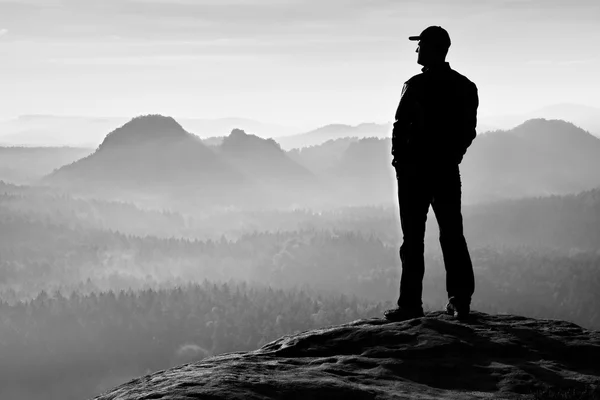 Einsamer Wanderer mit roter Mütze steht auf Gipfel im Felsenreich-Park und schaut in die Sonne — Stockfoto
